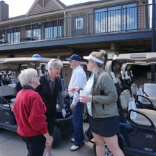 Golfers conversing around golf carts