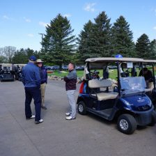 Group of three converse around golf carts